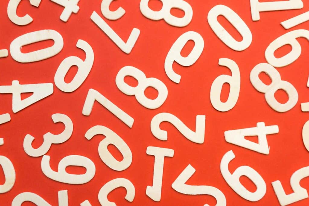 Abstract flat lay of white numbers on red background.
