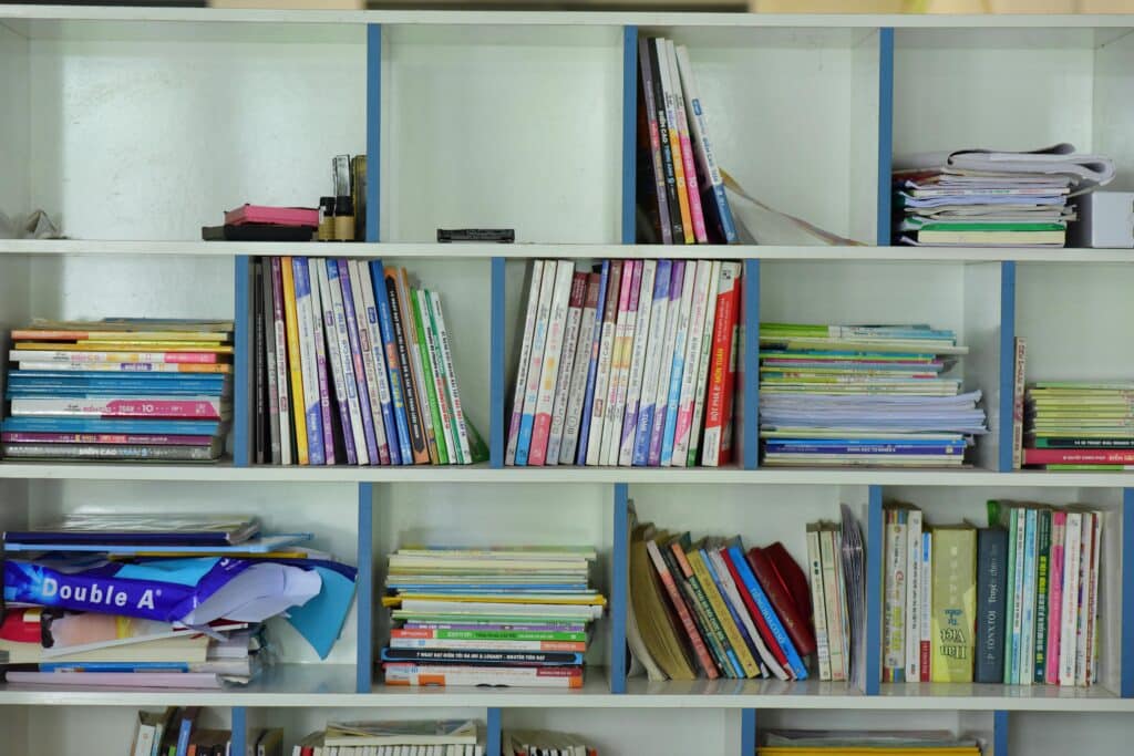 Neatly arranged bookshelf containing various educational books and documents.