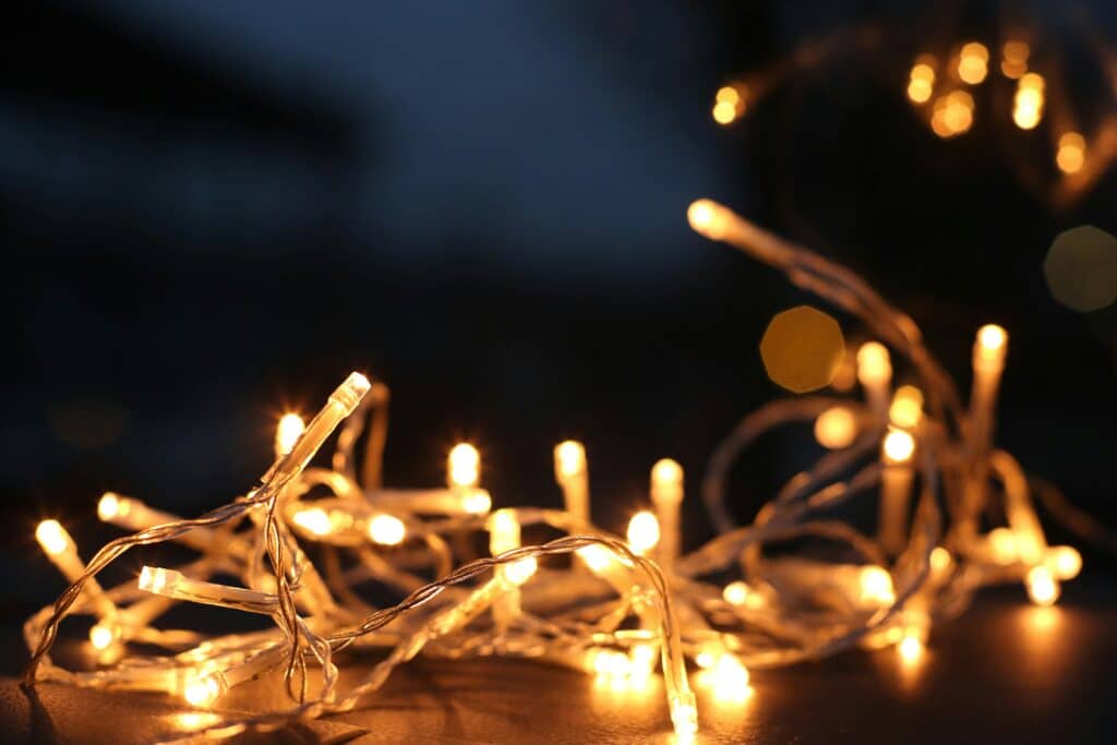 Close-up of warm LED string lights glowing against a dark background.