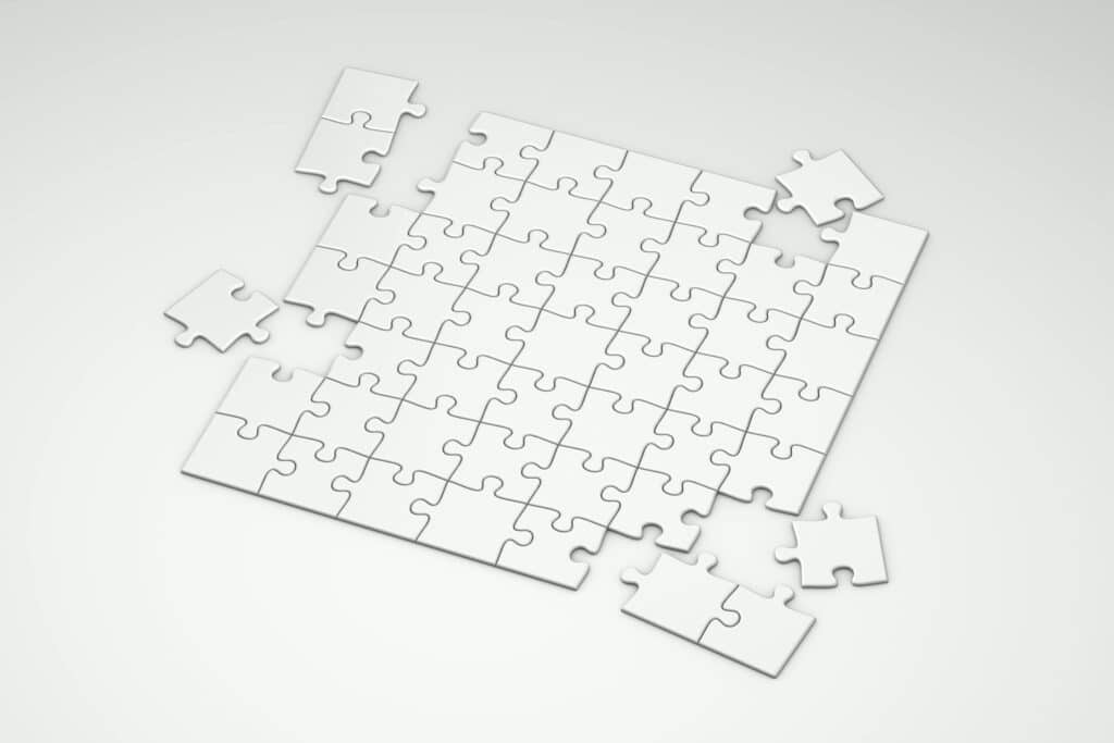 A top view of incomplete white puzzle pieces on a clean, minimalist background.