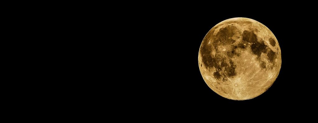 A vivid full moon against a dark, starless night sky, perfect for backgrounds.