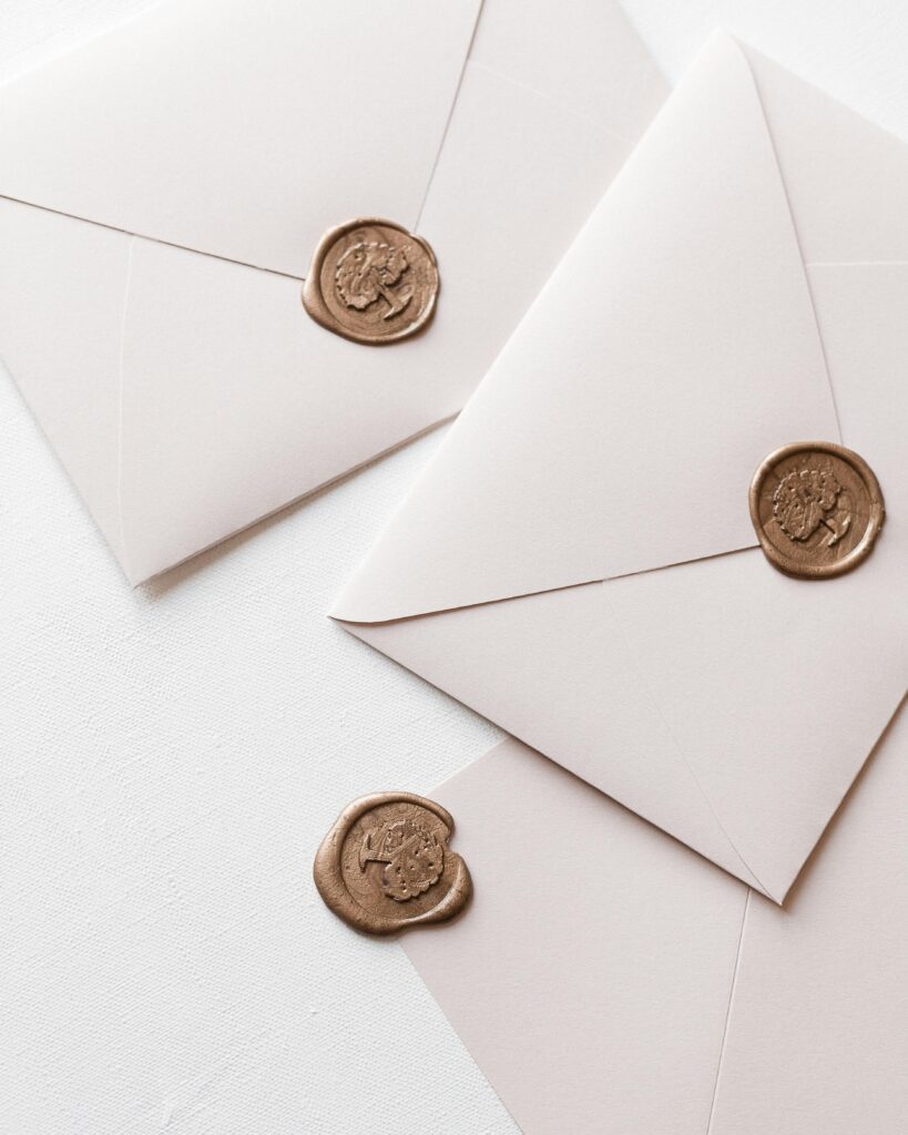 Close-up of white envelopes with wax seals, perfect for invitations or stationery themes.