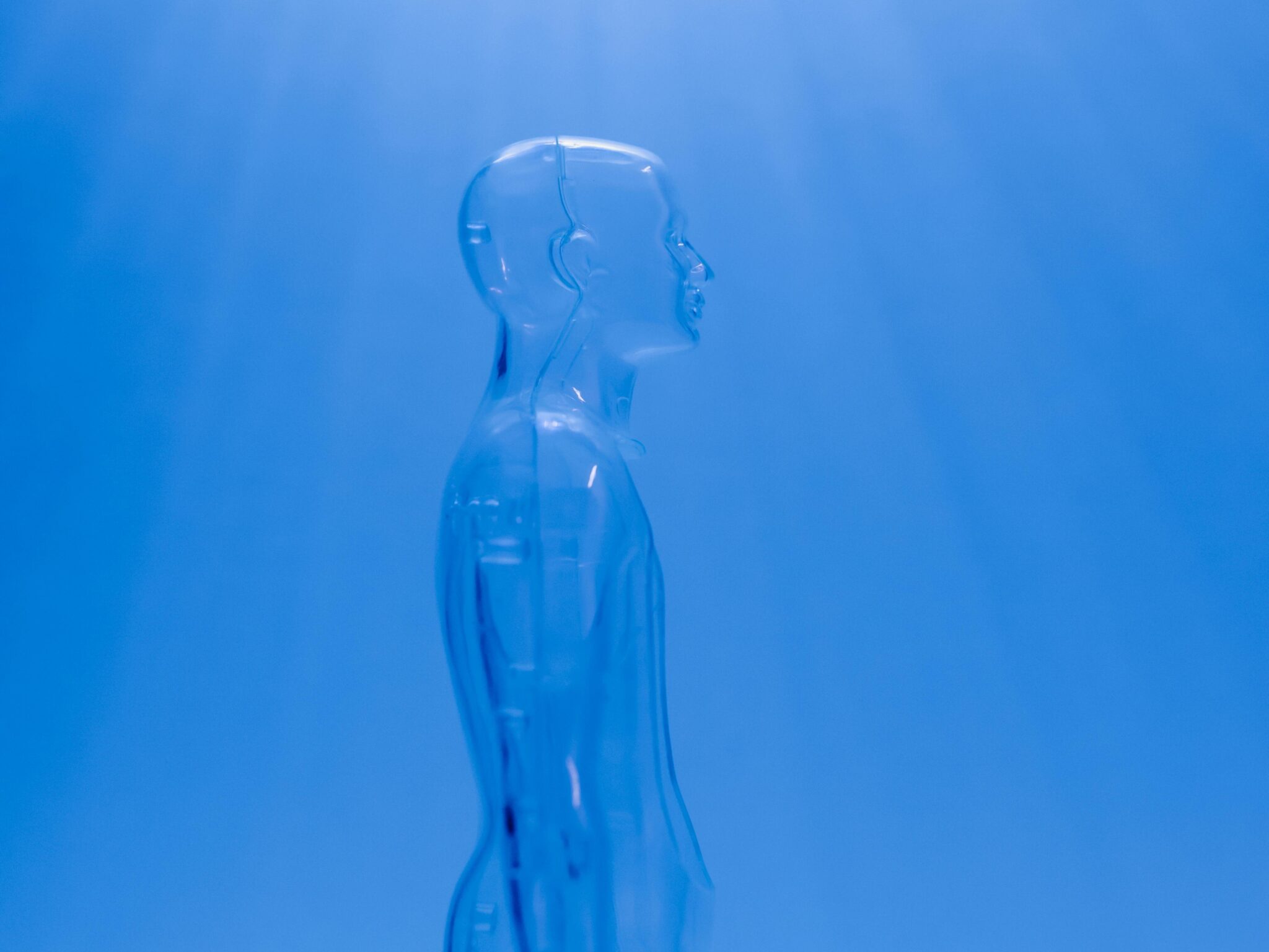 A transparent human figure under a bright blue light creating a futuristic ambiance.