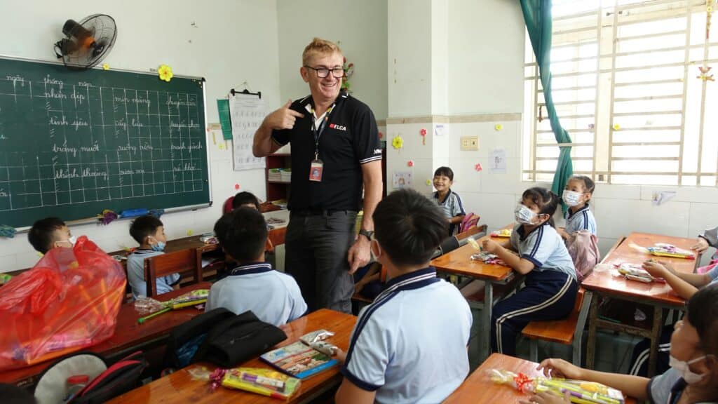 Teacher engaging with students in a vibrant Ho Chi Minh City classroom.