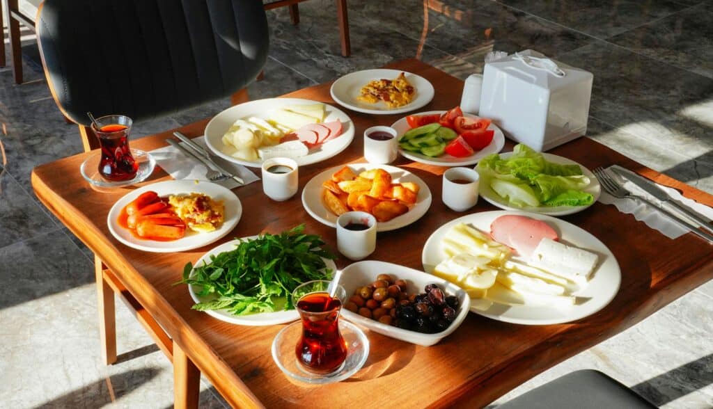 A vibrant traditional Turkish breakfast spread with tea, cheese, and fresh vegetables in Niğde, Türkiye.