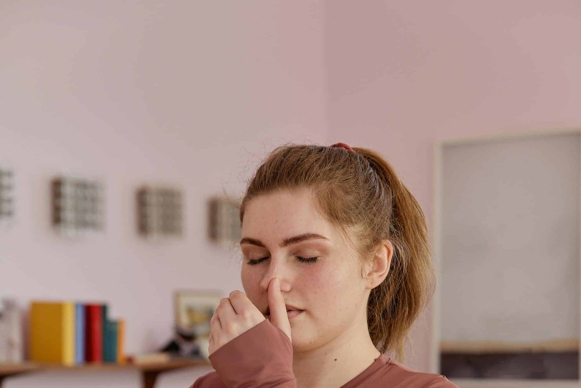 Plus-size woman in activewear performing breathing exercises indoors, promoting wellness and mindfulness.