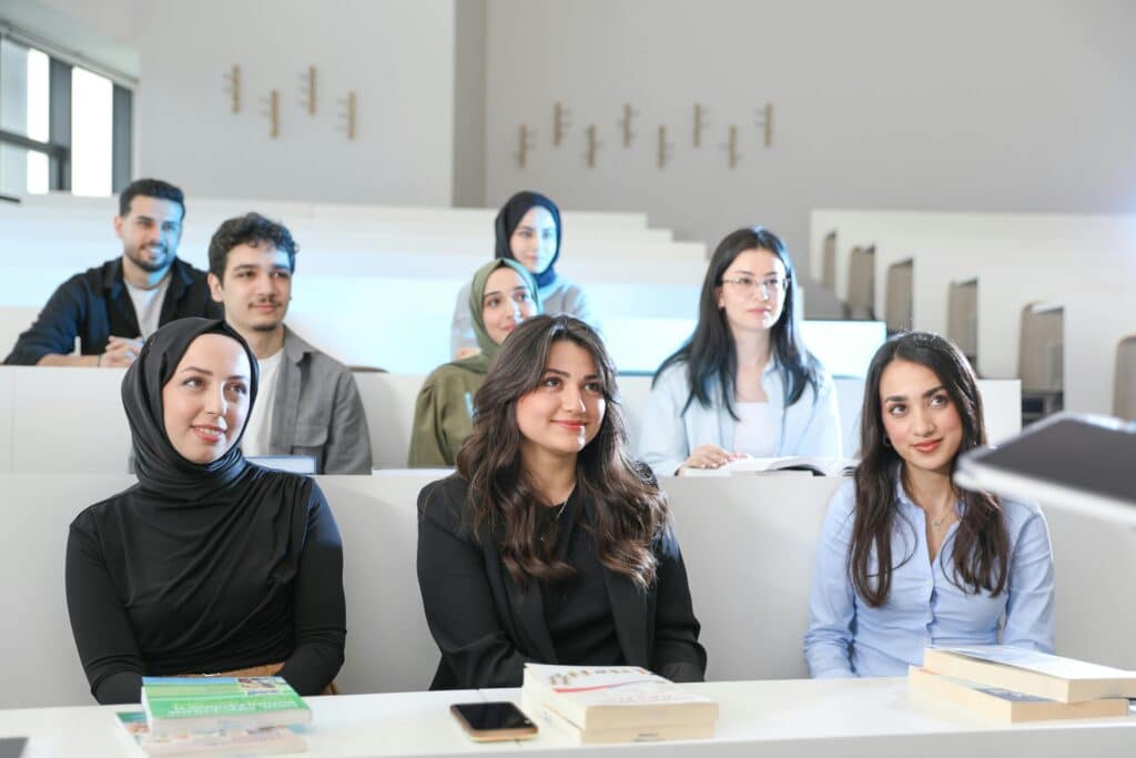 Group of diverse students in a university classroom during a lecture, engaged and attentive.