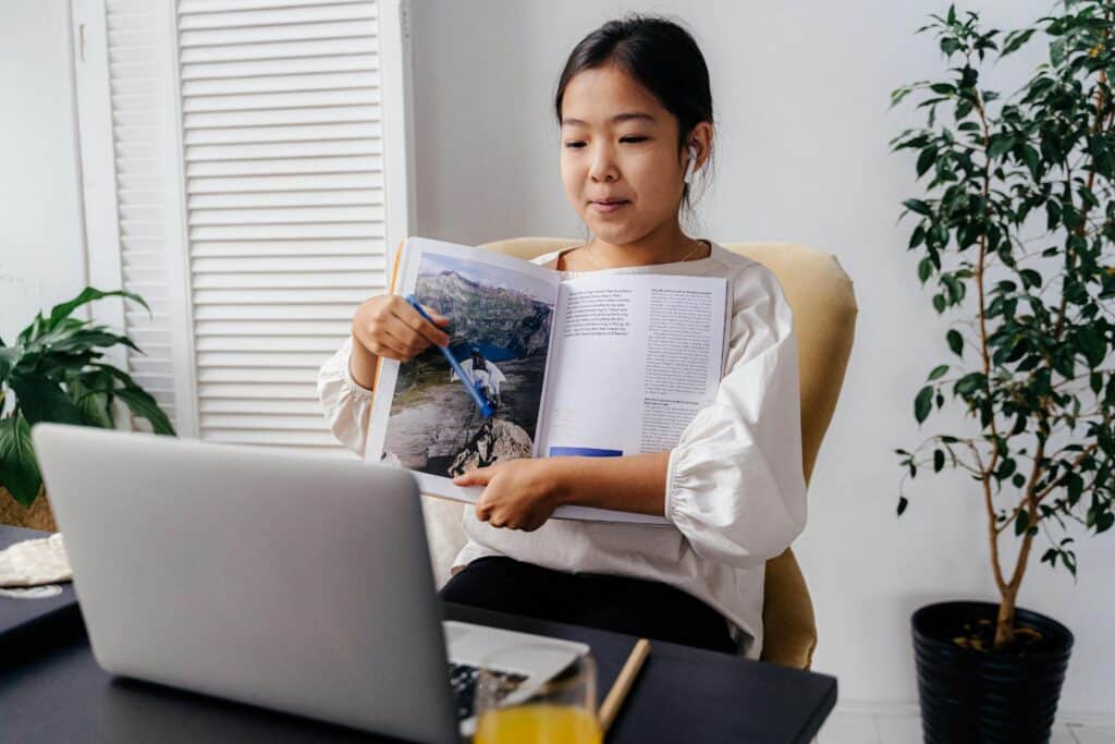 A young girl interacting with an online learning session at home, showcasing technology in education.