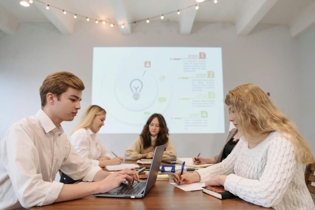 Group of young adults collaborating in a modern office meeting setting.