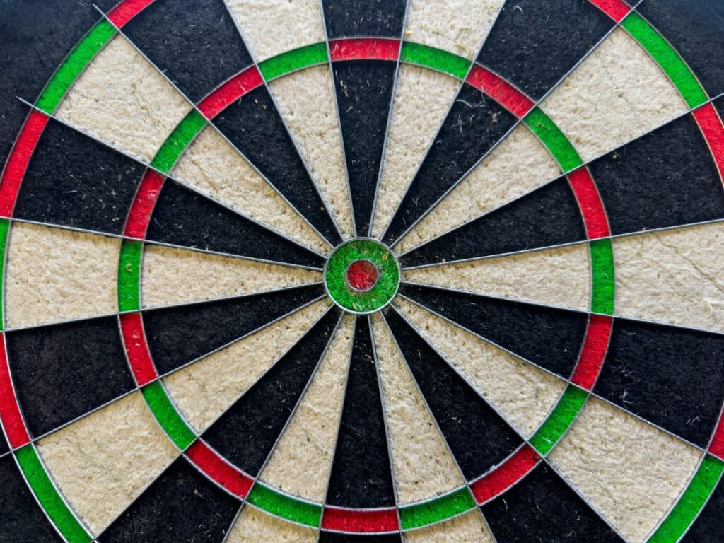 Close-up of a vintage dartboard showcasing wear and vibrant color patterns for recreation and sports themes.