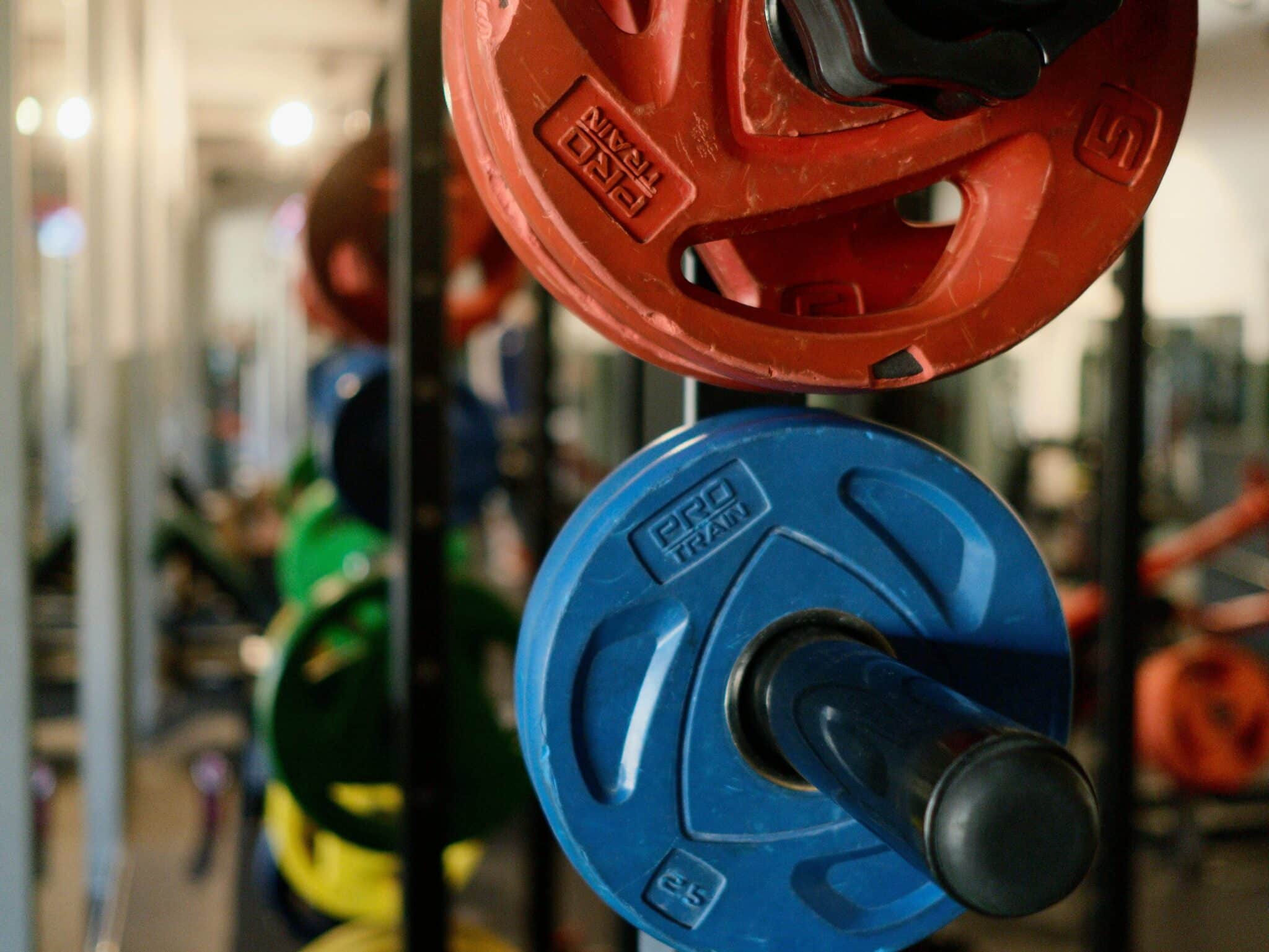 Stack of colorful weight plates in a modern gym, perfect for fitness enthusiasts.