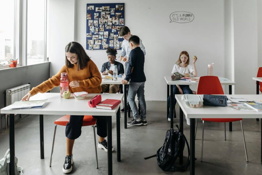 A group of students interacting in a bright and modern classroom setting, reflecting a collaborative learning environment.